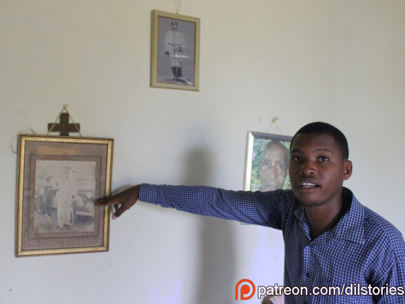 A man, claims to be a prince, pointing at an old photograph of a king, in Bukoba, Tanzania