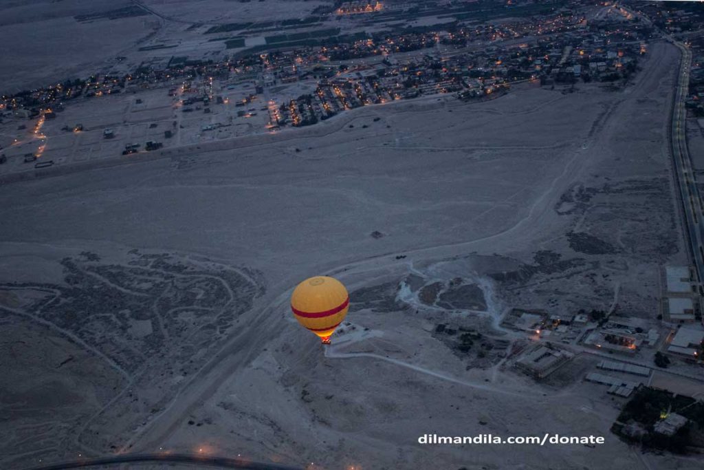 A hot-air balloon above West Bank in Luxor, the desert and villages in the background