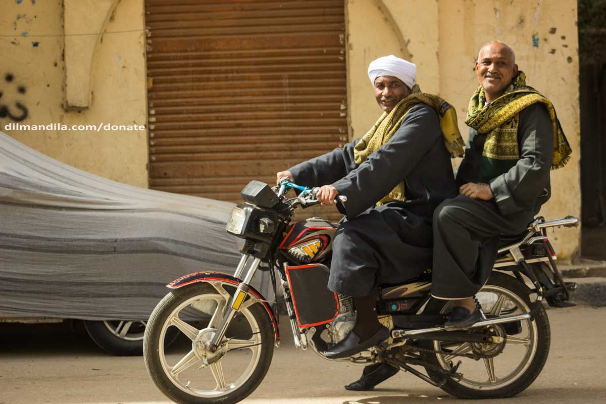 Two men on a motorcycle in the streets of Luxor